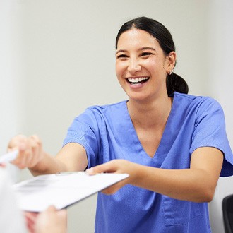 a patient being handed a dental insurance form