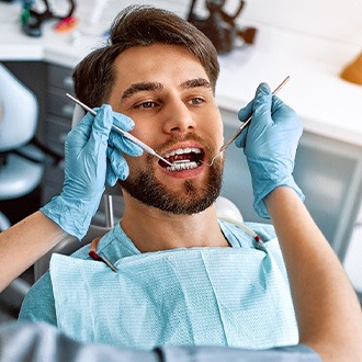 an adult with braces receiving dental treatment