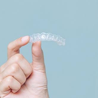 Patient holding Invisalign in Dayville