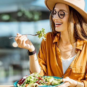 Woman smiling while eating lunch outside