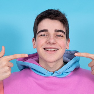 a teen pointing to his braces