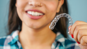 a person holding their Invisalign aligner