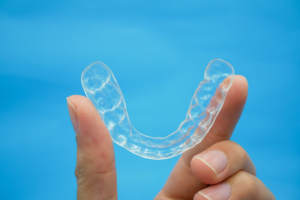 a patient holding their Invisalign aligner